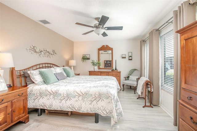 bedroom with visible vents, baseboards, light wood-style flooring, and a ceiling fan