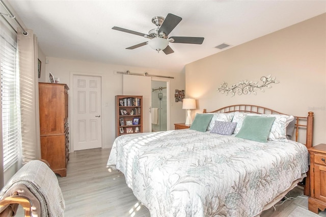 bedroom featuring visible vents, a ceiling fan, and light wood-style floors