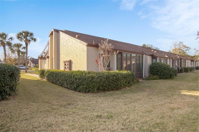 view of property exterior featuring stucco siding and a yard