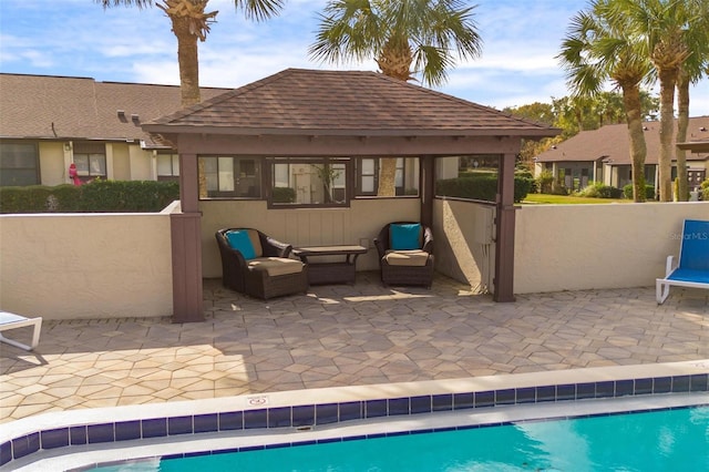 community pool featuring a patio area, an outdoor living space, and fence