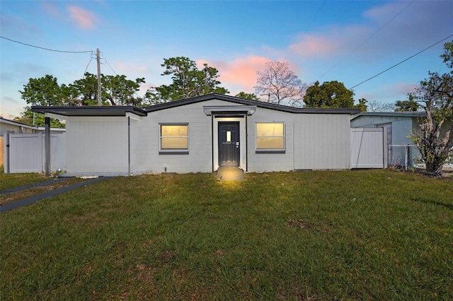 view of front facade featuring a yard and fence