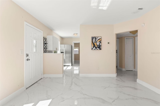 empty room featuring visible vents, baseboards, and marble finish floor