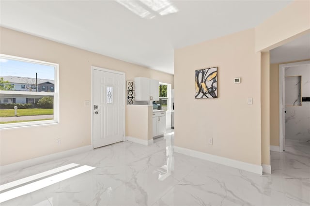 foyer with marble finish floor and baseboards