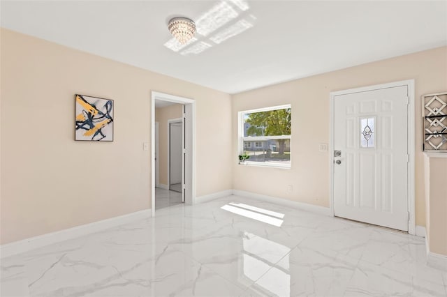 entryway with baseboards and marble finish floor