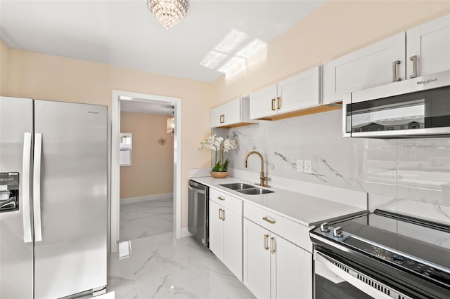 kitchen with a sink, stainless steel appliances, light countertops, marble finish floor, and tasteful backsplash