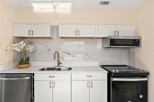 kitchen featuring a sink, white cabinets, visible vents, and stainless steel appliances