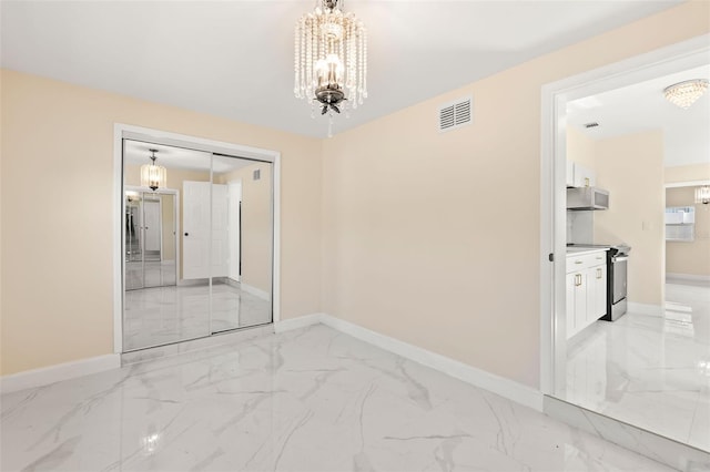 empty room featuring an inviting chandelier, visible vents, marble finish floor, and baseboards