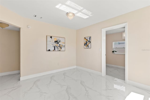 empty room with visible vents, marble finish floor, and baseboards