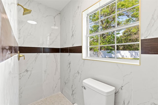 bathroom with toilet and a marble finish shower