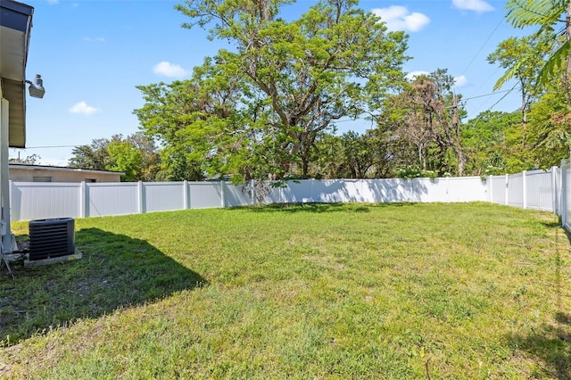 view of yard with central AC and a fenced backyard