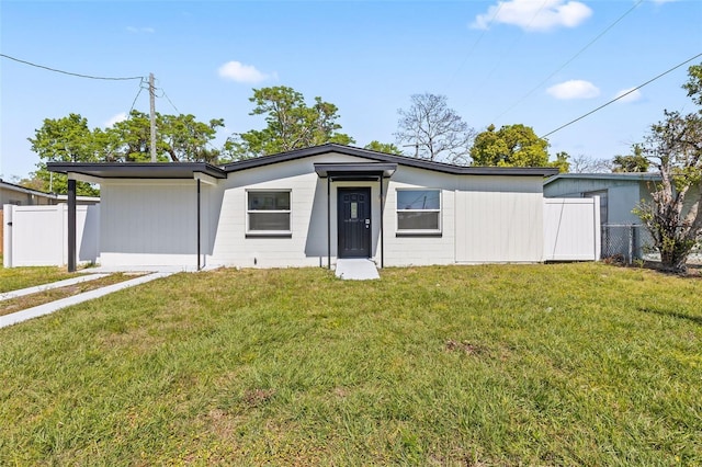 mid-century home featuring a front lawn and fence