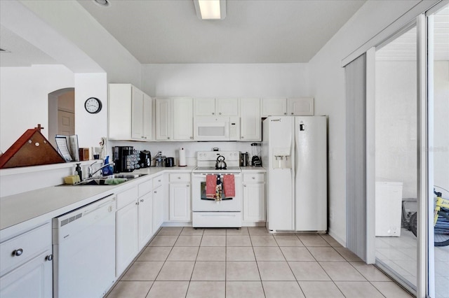 kitchen with light tile patterned floors, white appliances, white cabinetry, and light countertops