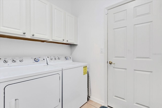 clothes washing area featuring light tile patterned floors, cabinet space, and separate washer and dryer