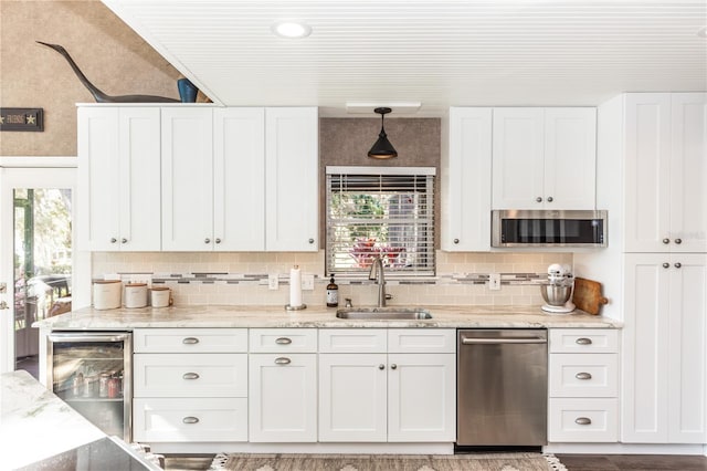 kitchen with a sink, stainless steel appliances, wine cooler, and white cabinets