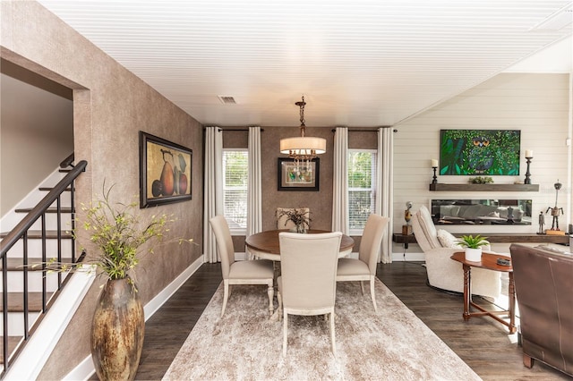 dining space with visible vents, a healthy amount of sunlight, wood finished floors, and stairs