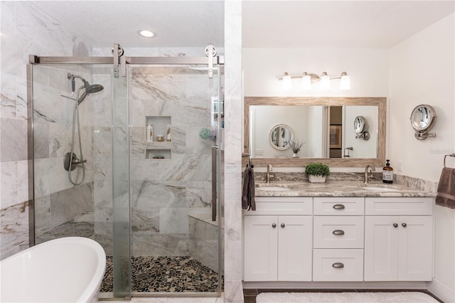 bathroom featuring a marble finish shower, a soaking tub, double vanity, and a sink