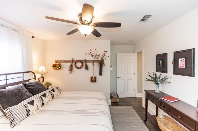 bedroom with wood finished floors, visible vents, and ceiling fan