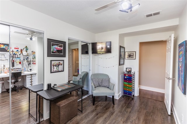 office space featuring visible vents, baseboards, a ceiling fan, and wood finished floors