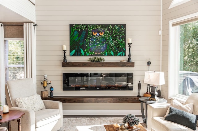 living room featuring a glass covered fireplace and a healthy amount of sunlight