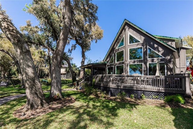 rear view of property with a lawn and a wooden deck