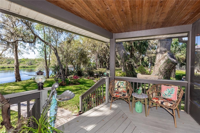 deck with a lawn and a water view