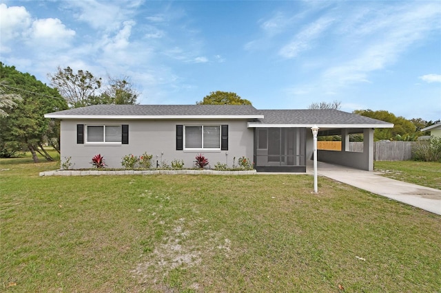 ranch-style house featuring a carport, driveway, a front lawn, and fence