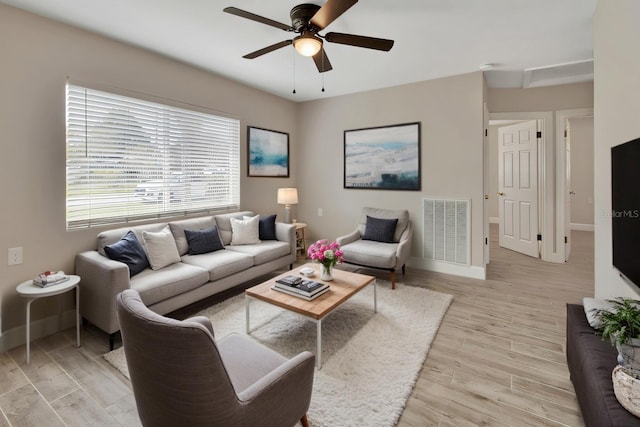 living area with light wood-style flooring, baseboards, and visible vents