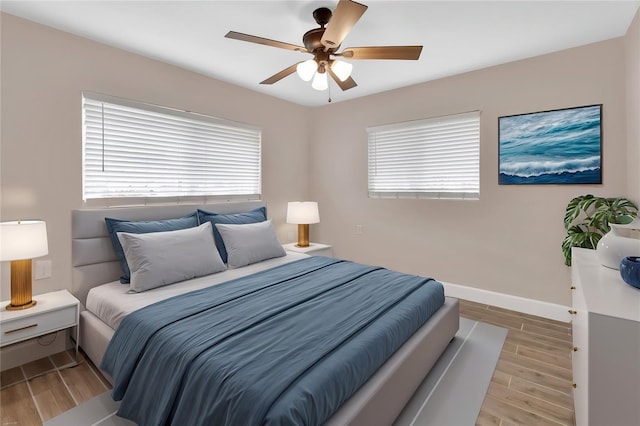 bedroom featuring ceiling fan, baseboards, and wood finished floors