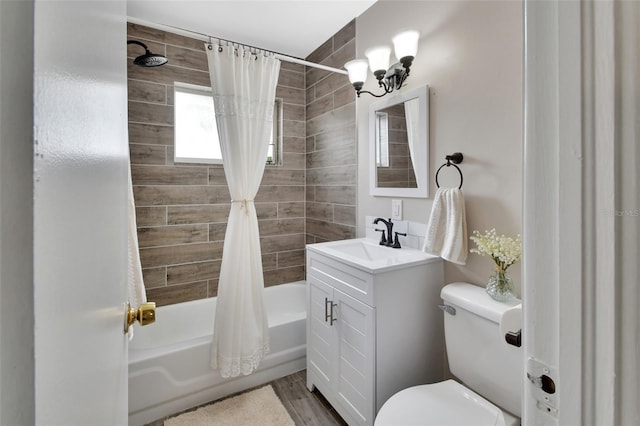 bathroom with vanity, toilet, wood finished floors, and shower / tub combo