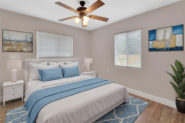 bedroom with ceiling fan, baseboards, and wood finished floors