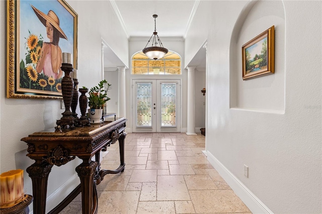 foyer with baseboards, ornamental molding, french doors, stone tile flooring, and ornate columns