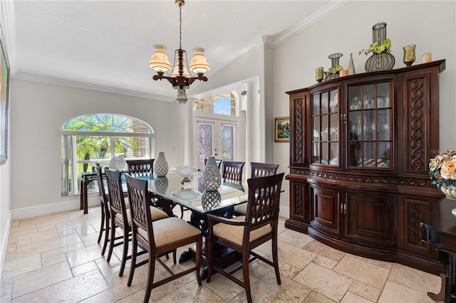 dining area featuring stone tile flooring, a chandelier, crown molding, and baseboards