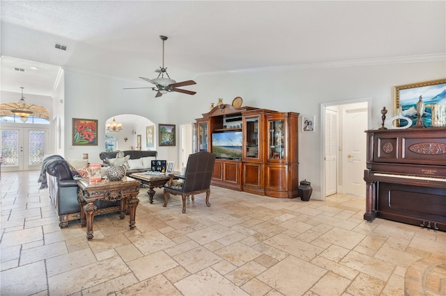 living area with stone tile floors, ceiling fan, and crown molding