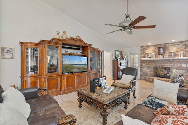 living area featuring ornamental molding, stone tile floors, a fireplace, ceiling fan, and vaulted ceiling