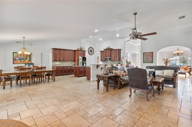 living room with high vaulted ceiling, ornamental molding, ceiling fan with notable chandelier, stone tile floors, and recessed lighting