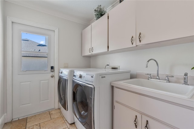 washroom with a sink, stone tile floors, cabinet space, separate washer and dryer, and crown molding