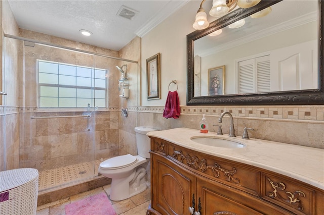 bathroom with visible vents, toilet, tile walls, a shower stall, and vanity