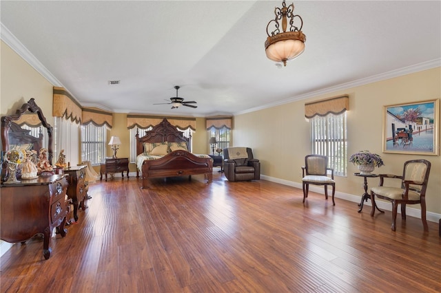 bedroom with visible vents, multiple windows, crown molding, and wood finished floors