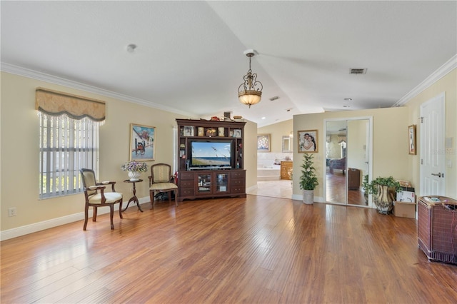 living room featuring visible vents, crown molding, baseboards, vaulted ceiling, and wood finished floors
