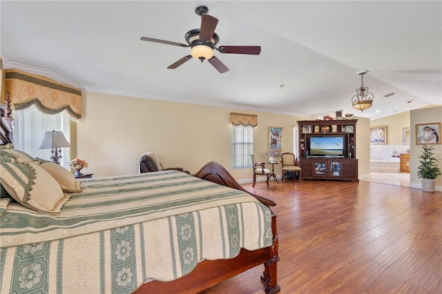 bedroom with baseboards, wood finished floors, crown molding, and vaulted ceiling