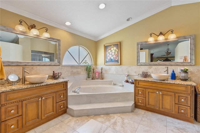 bathroom featuring crown molding, two vanities, vaulted ceiling, and a sink