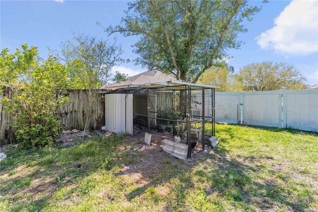 view of yard with an outdoor structure, a fenced backyard, and exterior structure
