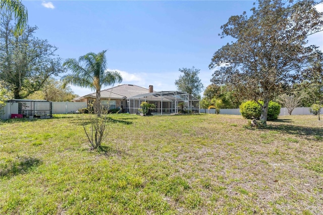 view of yard featuring glass enclosure and a fenced backyard