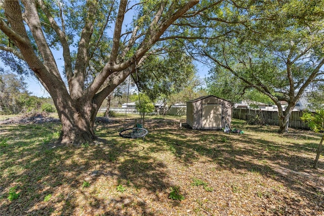 view of yard featuring an outdoor structure, a fenced backyard, and a shed