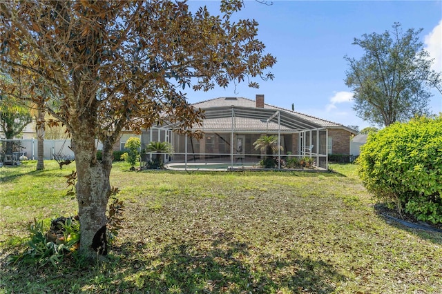 view of yard featuring glass enclosure, fence, and a fenced in pool
