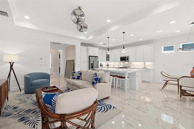 living area with recessed lighting, a raised ceiling, marble finish floor, and ornamental molding