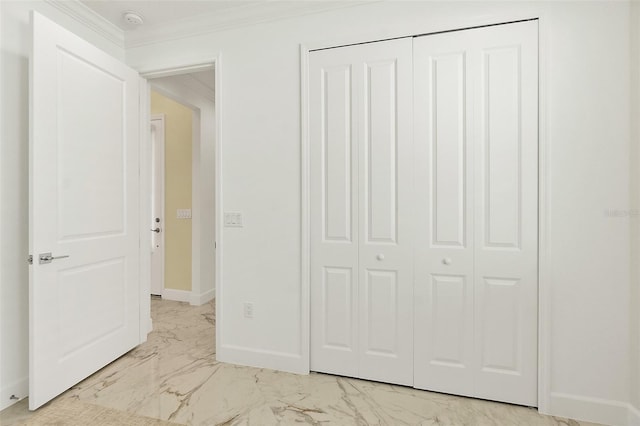 unfurnished bedroom featuring baseboards, marble finish floor, a closet, and ornamental molding