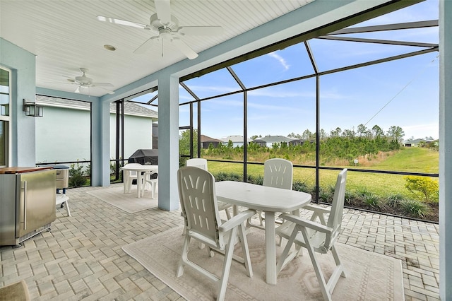 sunroom / solarium featuring a ceiling fan