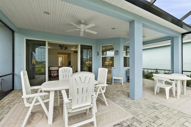 view of patio / terrace featuring a lanai, ceiling fan, and outdoor dining space