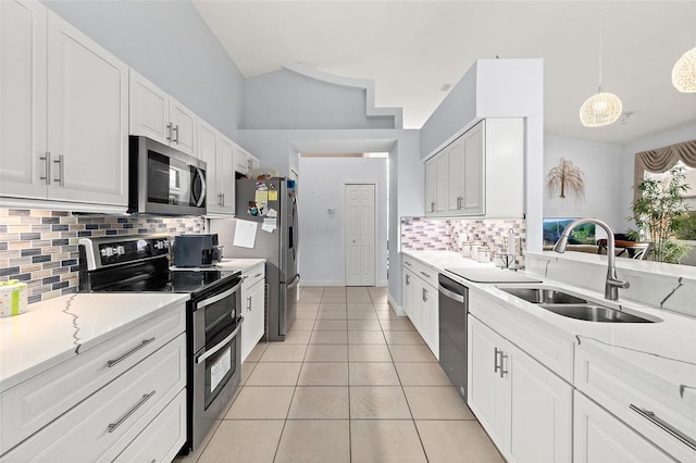 kitchen with light tile patterned floors, a sink, decorative backsplash, white cabinets, and appliances with stainless steel finishes